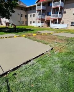Fresh concrete slab poured beside a lawn near apartments in Apex, NC