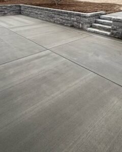 Smooth concrete patio with steps and a stone wall in Apex, NC